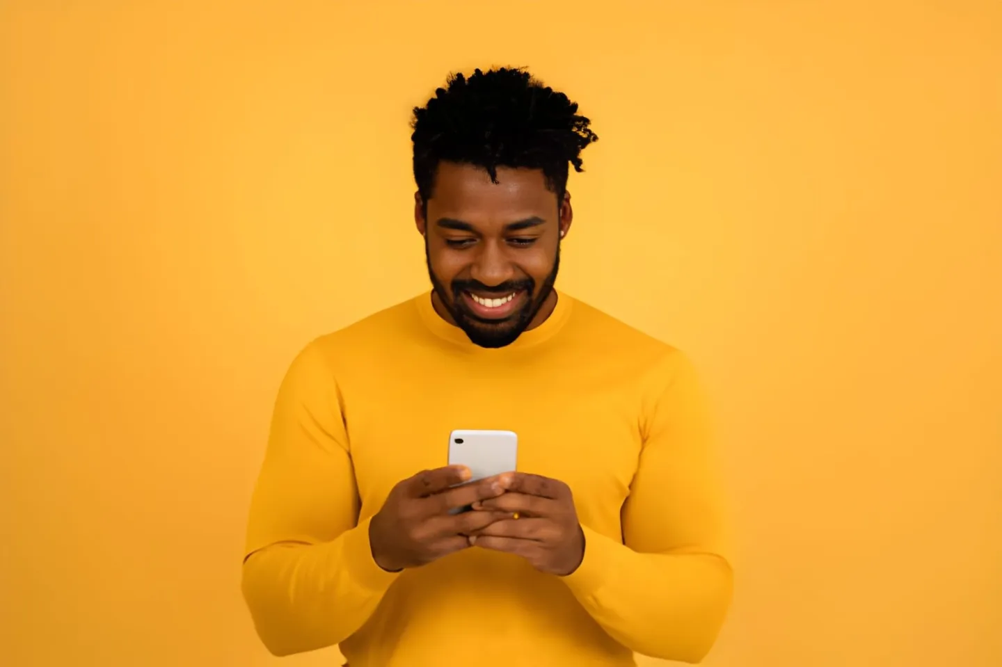 Smiling man comparing social media services on his phone before choosing one