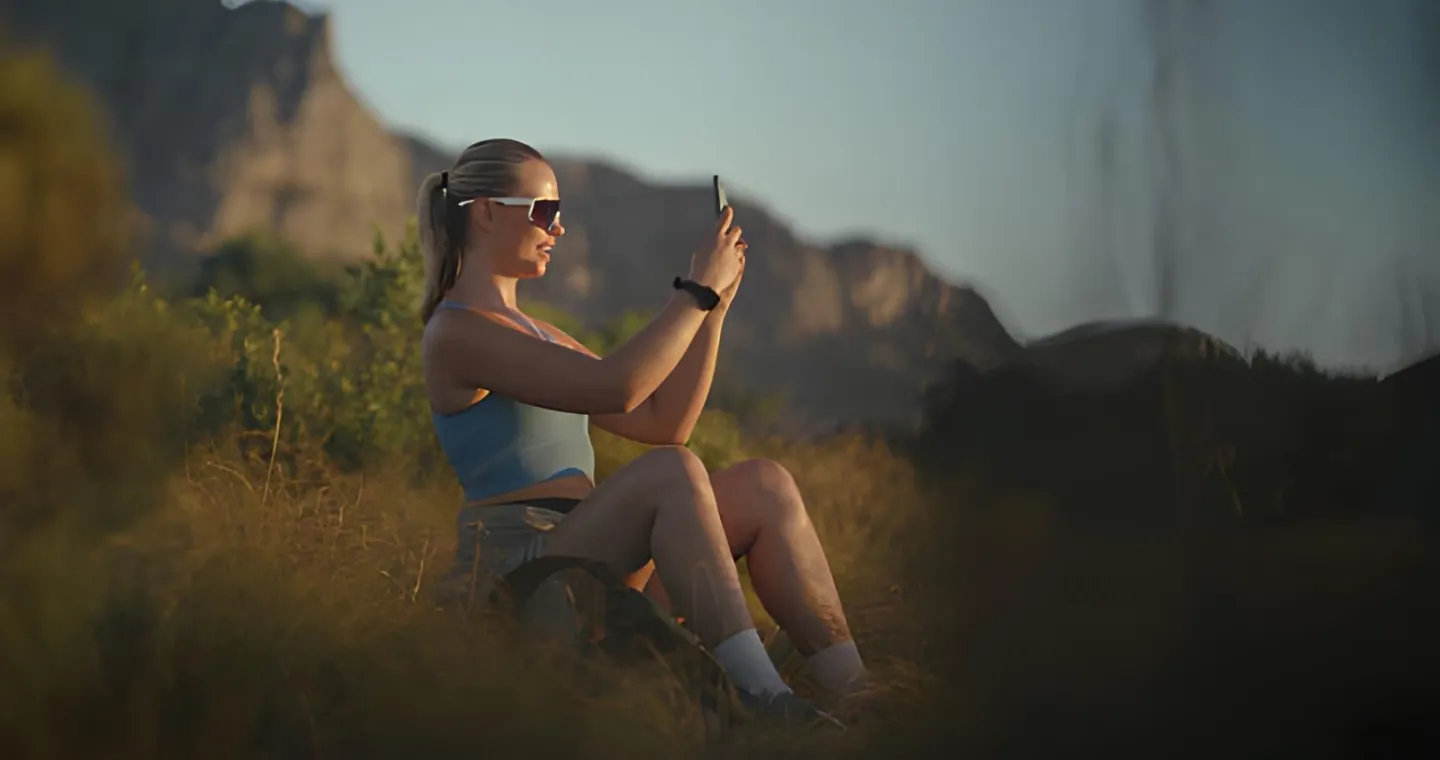 Woman recording herself with a smartphone outdoors for a YouTube video