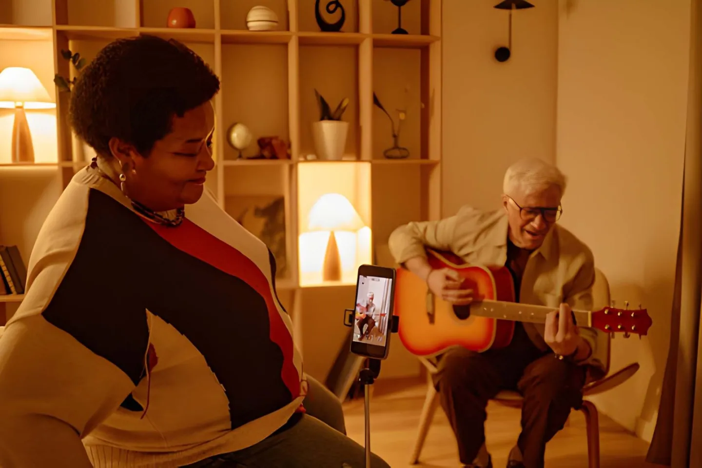 Musician playing guitar while a phone on a tripod records an Instagram Reel