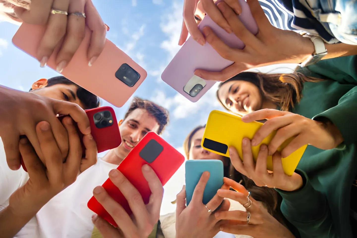 Friends gathered around looking at their phones together